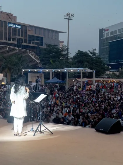 A wide shot of Nayab Midha captivating a large audience at Spoken'25. My job is to ensure the artist feels confident and looks great, even from a distance.