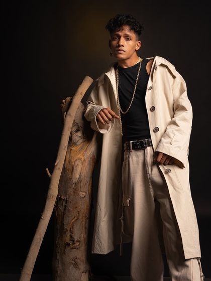 A fashion-forward pose from a studio shoot, featuring a beige trench coat and layered chains. This shows my professional and creative side.
