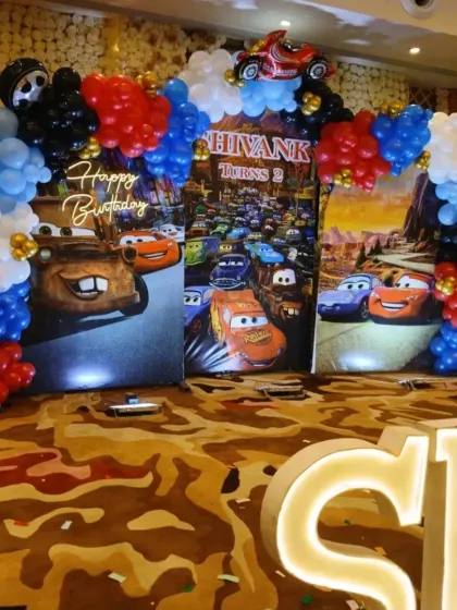 A full view of another Cars-themed party, this one for Shivank's second birthday, with a large backdrop and balloon arch.