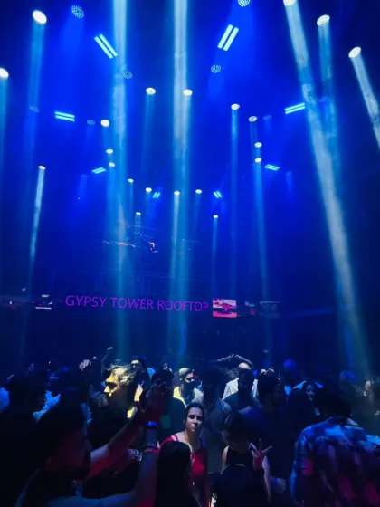 The atmosphere of the club is everything. Here, beams of blue light cut through the haze, creating a perfect backdrop for a night of dancing.