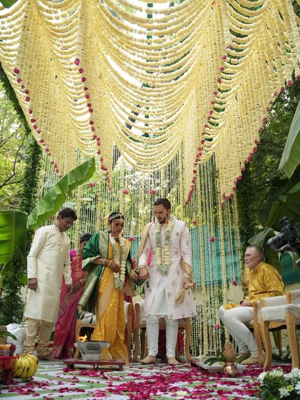 A sacred moment under a canopy of flowers. This view from within the mandap shows the couple during their ceremony, surrounded by a cascade of tuberose garlands that created a beautifully intimate and fragrant space.