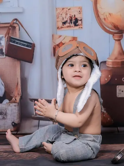 A close-up of a baby boy in an aviator hat, part of our vintage traveler theme.