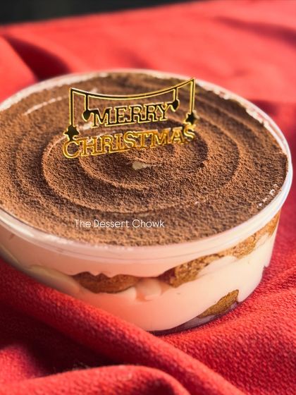 My classic Tiramisu in a round tub, decorated with a "Merry Christmas" topper for the festive season.
