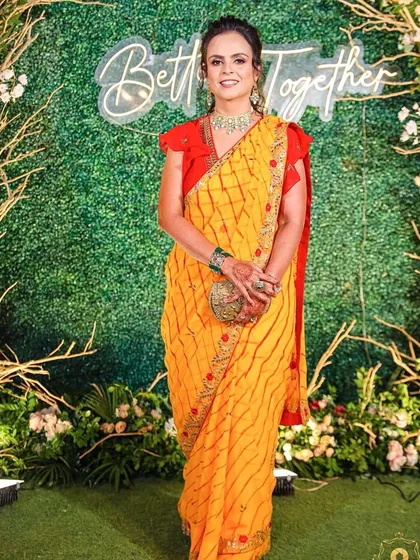 A vibrant and fun party makeup look. The client's bright yellow saree is complemented by fresh, glowing makeup that makes her look ready to celebrate.