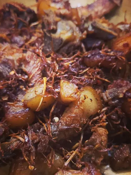 A macro shot showing the texture of the shredded dry bamboo shoots mixed in with the juicy pork pieces. This dish is a true explosion of Naga flavours.