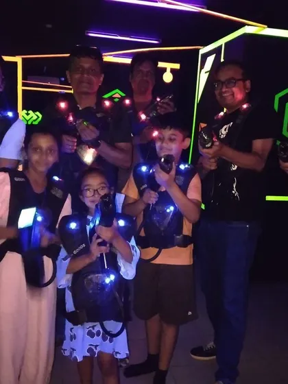 A family of all ages, from kids to grandparents, geared up for a laser tag battle. It's a fun activity that everyone can enjoy together.