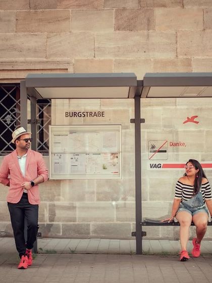 A playful interaction during a pre-wedding shoot at a European bus stop, showing how we find creative opportunities in everyday settings.