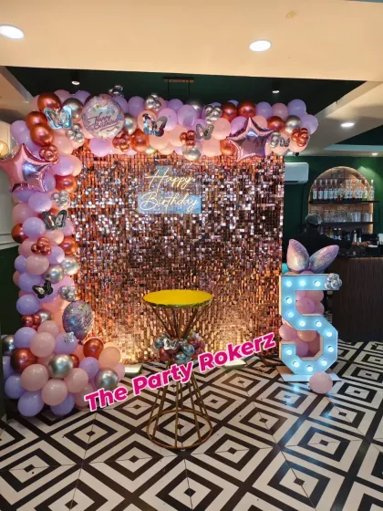 A different angle of the 5th birthday party, showing how the decor elements like the balloon arch, sequin wall, and marquee number come together to transform the space.