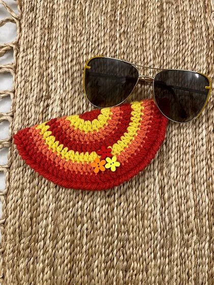 This is my quirky 'Taco Specs Case' in warm sunset colours, shown here protecting a pair of sunglasses. It's a fun, semi-circular design that keeps your glasses safe and easy to find.