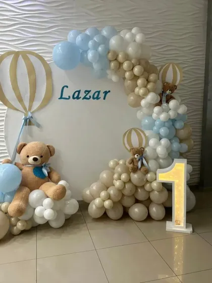 A neutral-toned teddy bear theme for Lazar's first birthday, with beige, blue, and white balloons.