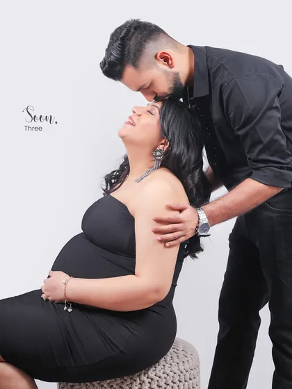 A tender moment captured in the studio. The partner's gentle kiss on the forehead is a simple, powerful gesture of love and support during this special time.