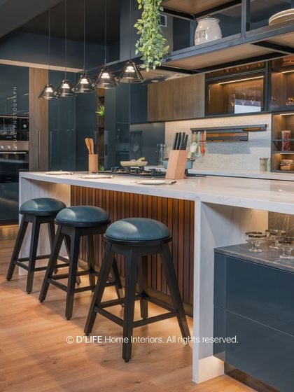 A modern kitchen island with stylish bar stools, perfect for casual meals. The design features a mix of wood, white countertops, and industrial-style overhead shelving.