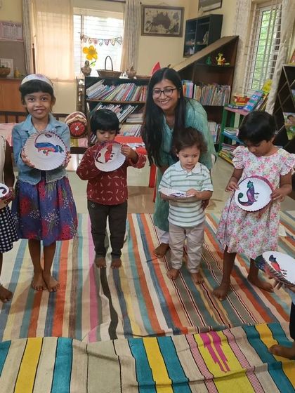The children are thrilled to show off the chameleon crafts they painted.