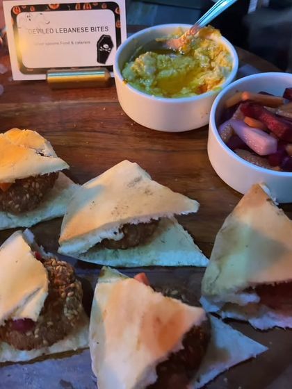 'Stapled Lebanese Bites' served with hummus and pickles. The creative, spooky name adds a playful horror twist to a classic falafel pita appetizer.