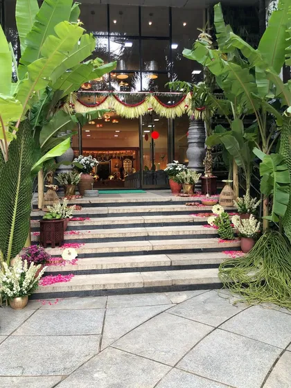The grand entrance to a naming ceremony we designed with a South Indian village theme. We used traditional elements like banana trees, stone pillars, and scattered flower petals to create an authentic and welcoming atmosphere.