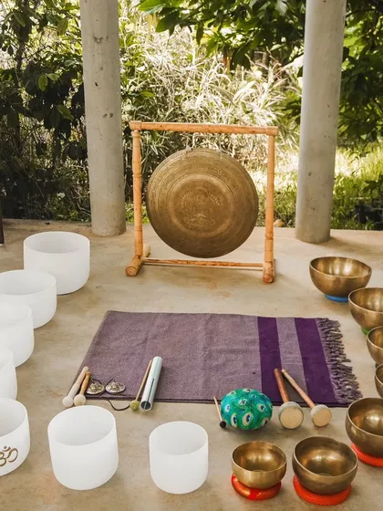 These are the sacred tools of my practice. This setup includes a collection of white crystal singing bowls, traditional bronze Tibetan bowls, and a large Chau gong, each chosen for its unique frequency and ability to facilitate deep healing.