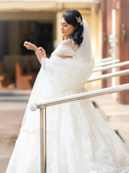 An elegant and candid-style bridal portrait. The soft light and the bride's pose create a graceful and timeless image.