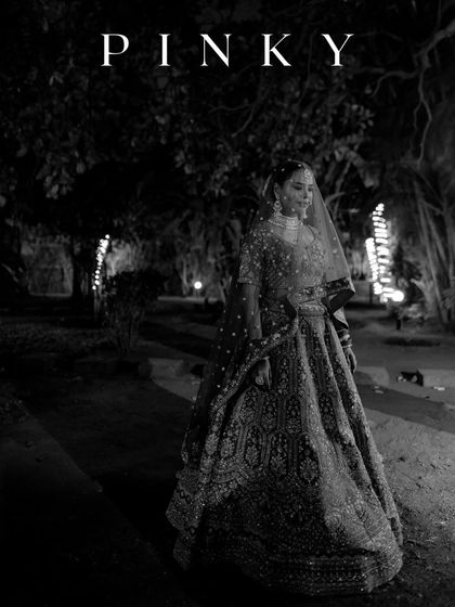 A dramatic black and white portrait of the bride at night. The soft lighting and outdoor setting create a moody and romantic image, with her name "PINKY" featured.