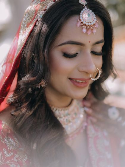 A serene close-up of a bride with her eyes closed, showcasing her soft makeup and delicate jewelry.