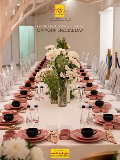 A detailed view of our elegant table setting, showcasing the delicate balance of modern and classic elements. The pink dinnerware, crystal clear glasses, and fresh floral arrangements come together to create a luxurious dining experience.